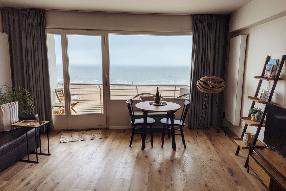 Apartment living room with large windows looking out over the sea