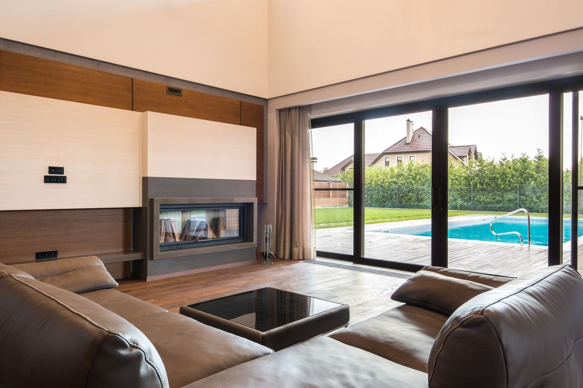 Living room with wide sliding glass doors opening onto a pool terrace